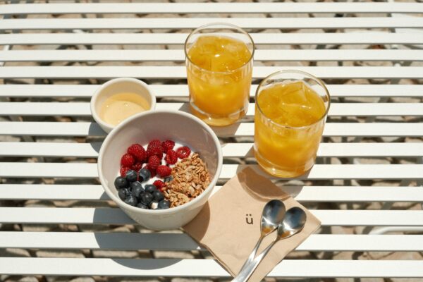A bowl of berries with versatile cottage cheese and two glasses of orange juice.