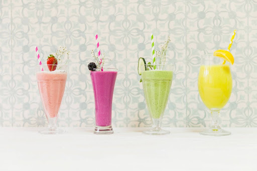 Cottage cheese protein smoothies in four colourful glasses with fruits.