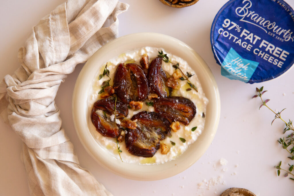 Close-up of a fried date bowl dish with caramelised dates, walnuts, thyme, and creamy cottage cheese.