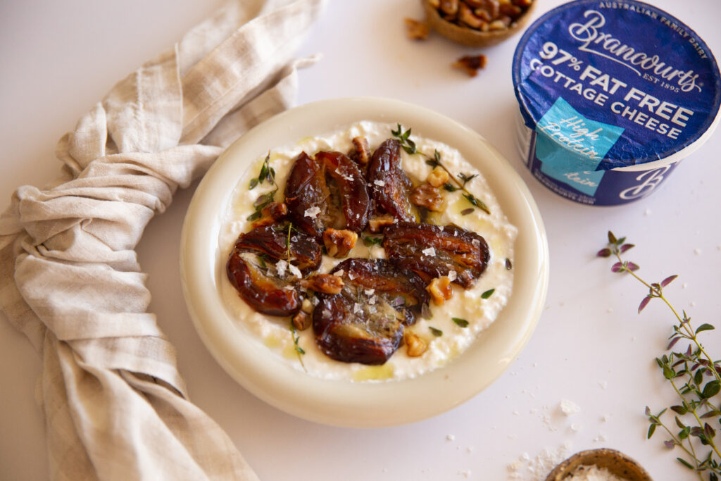 Delicious fried date bowl dish showcasing blistered dates and seasoned walnuts on creamy cottage cheese.