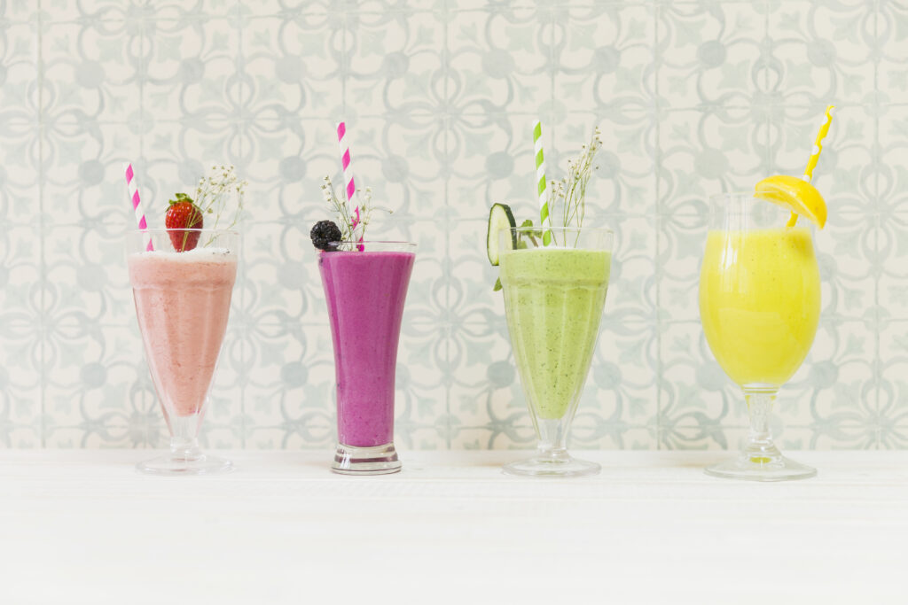 ttage cheese protein smoothies in four colourful glasses with fruits.