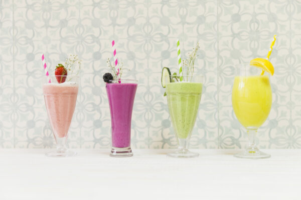ttage cheese protein smoothies in four colourful glasses with fruits.