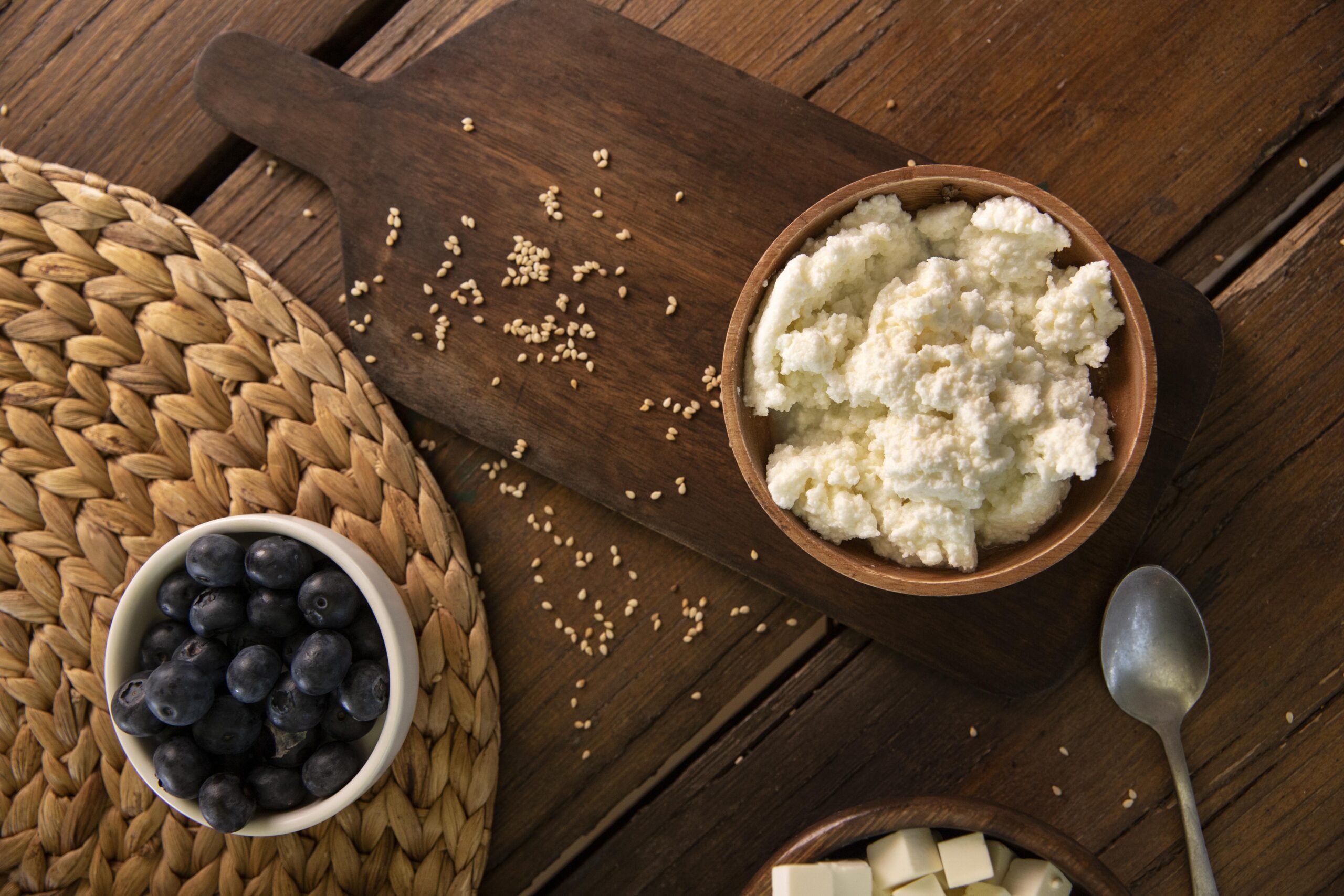 Cottage cheese hacks shown with wooden bowl and fresh blueberries.